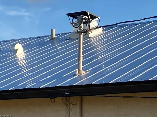 Exterior view of solar attic vent and a metal roof