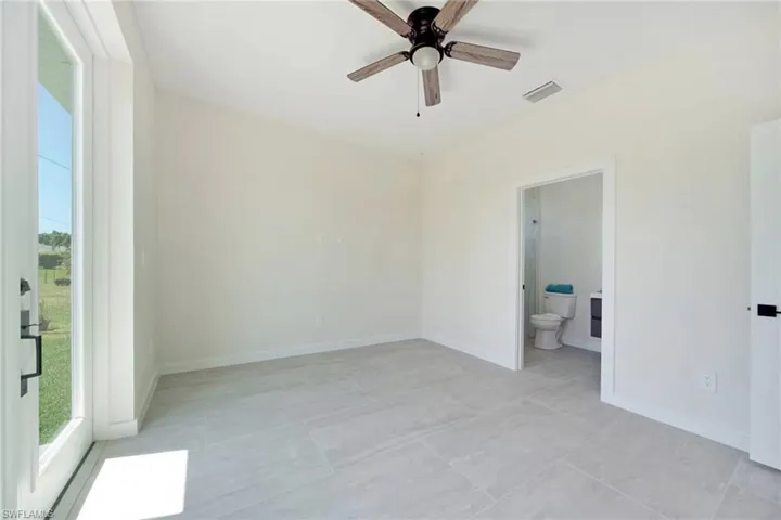 Room featuring large format tile flooring, a contemporary ceiling fan, and a glass-paneled exterior door