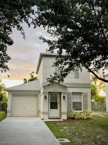 View of front of property featuring a garage and paved driveway