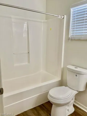 Upstairs Bathroom featuring toilet, and shower / bathing tub combination