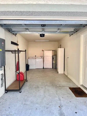 Garage with washer and dryer, a garage door opener, and additional refrigerator