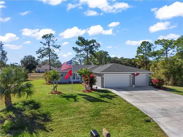 Ranch-style home with an attached garage, a front yard, and concrete driveway