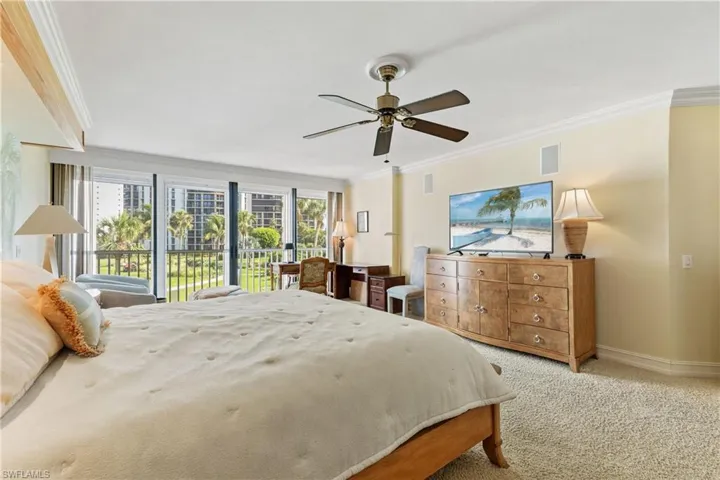 Carpeted bedroom with multiple windows, crown molding, access to outside, and ceiling fan