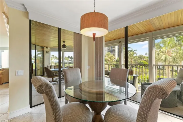 Dining room with ceiling fan, light tile floors, and ornamental molding