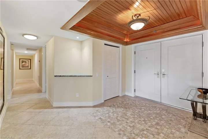 Foyer featuring wood ceiling and light tile floors