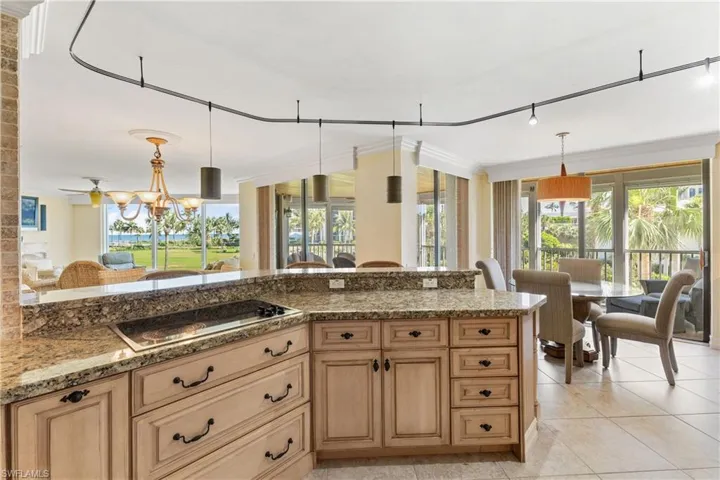 Kitchen with track lighting, plenty of natural light, crown molding, and pendant lighting
