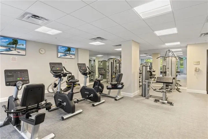 Workout area featuring light carpet and a paneled ceiling