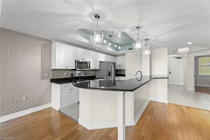 view of curved breakfast bar granite top and view into bedroom 2