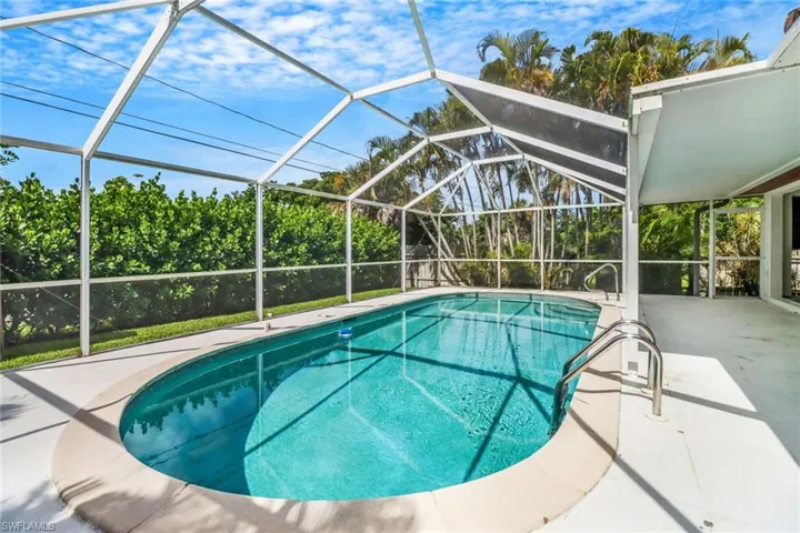 View of swimming pool featuring a patio area and glass enclosure