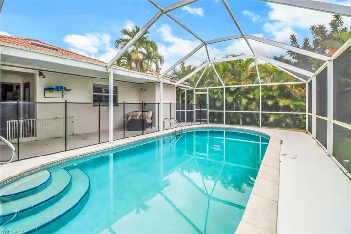 View of swimming pool featuring a patio and glass enclosure