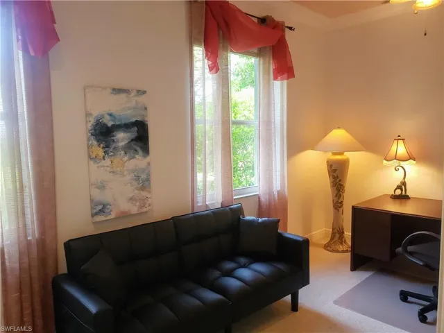 Office room with desk, extensible coach, carpet flooring and plenty of natural light