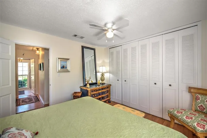 Bedroom with hardwood / wood-style floors, a closet, and a textured ceiling