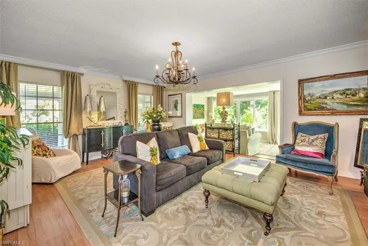 Living room featuring ornamental molding, light hardwood / wood-style floors, and a wealth of natural light