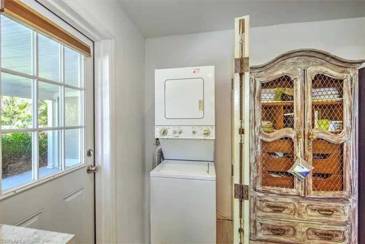Clothes washing area featuring stacked washer and dryer
