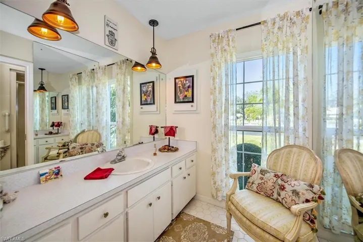 Bathroom featuring vanity, a wealth of natural light, and tile patterned floors