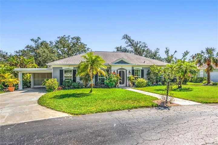 Ranch-style home with a front yard and a carport