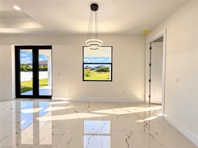 Polished large-format tile flooring with marble-style veining, double-pane window with black frame, black-framed glass-paneled double doors, and tiered circular LED pendant light fixture