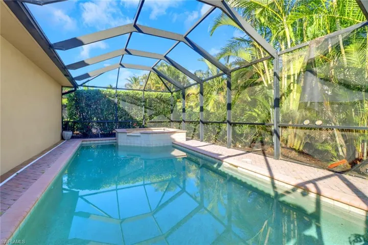View of pool with an in ground hot tub and a lanai