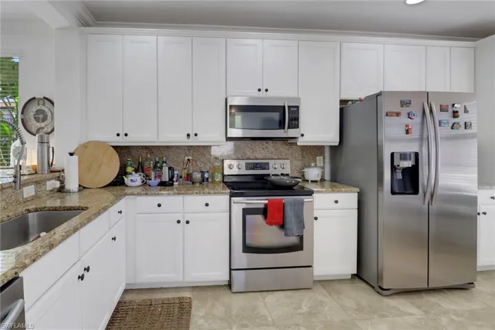 Kitchen with white cabinets, plenty of natural light, and stainless steel appliances