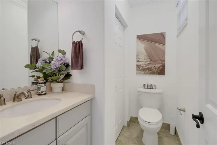 Bathroom featuring tile patterned floors, vanity, toilet, and ornamental molding