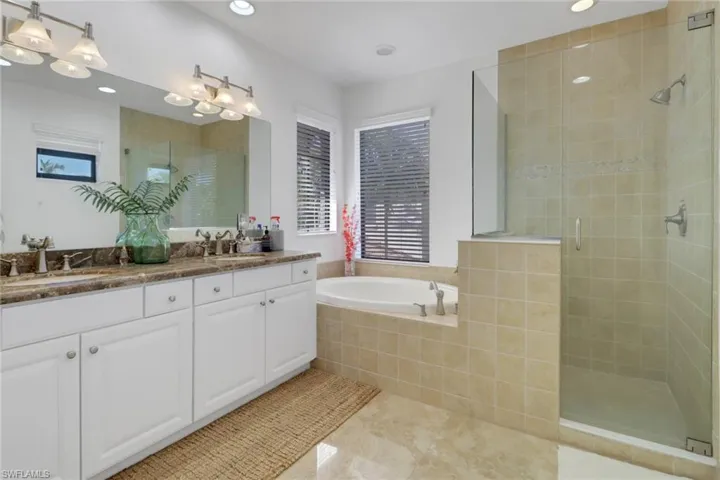 Bathroom with tile patterned floors, vanity, and plus walk in shower