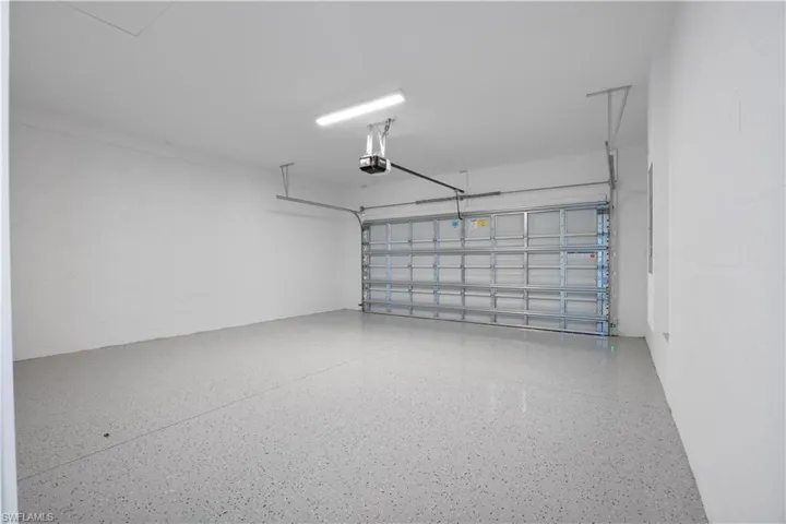 Garage featuring concrete block wall and a garage door opener