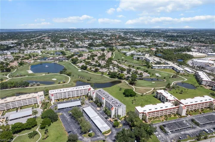 Aerial view of property and surrounding area with a local golf course and a nearby body of water