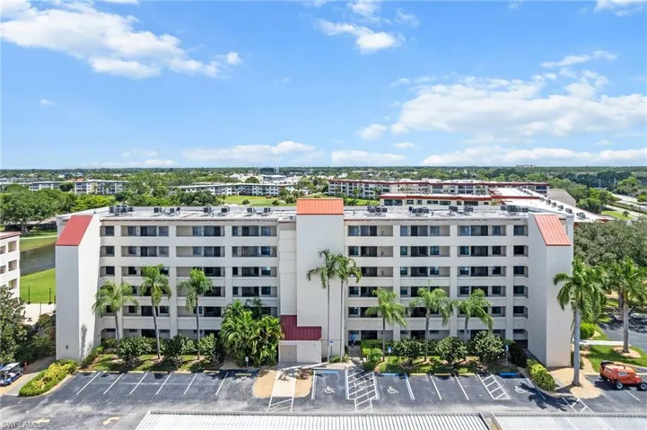 View of apartment building / complex featuring uncovered parking