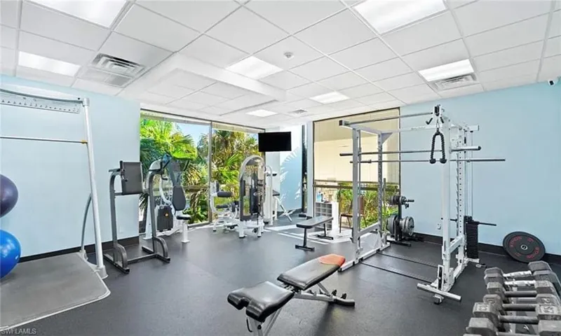 Exercise room featuring a paneled ceiling and a wall of windows