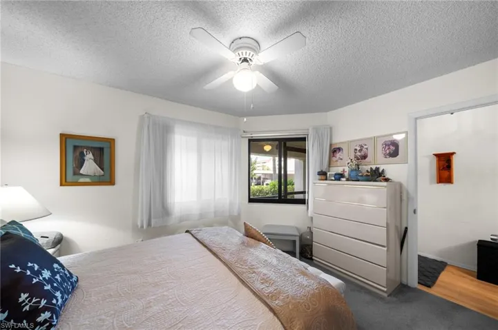 Bedroom with a textured ceiling, ceiling fan, and carpet flooring