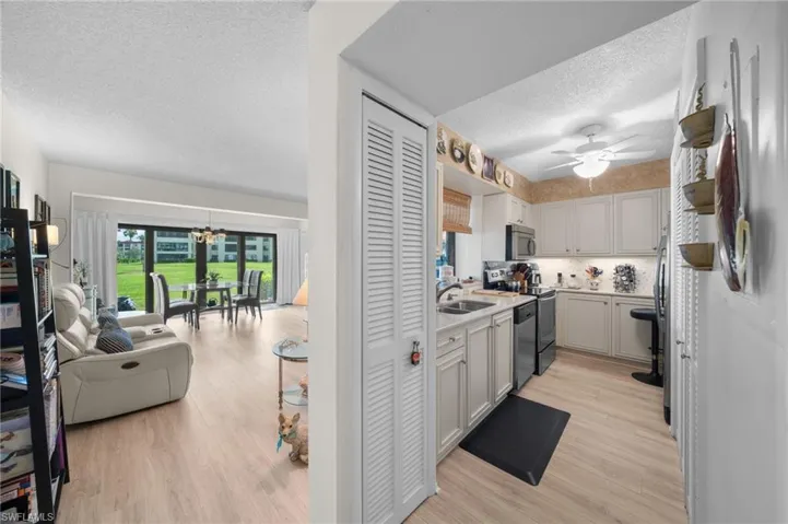 Kitchen featuring light countertops, a textured ceiling, light wood finished floors, stainless steel appliances, and open floor plan