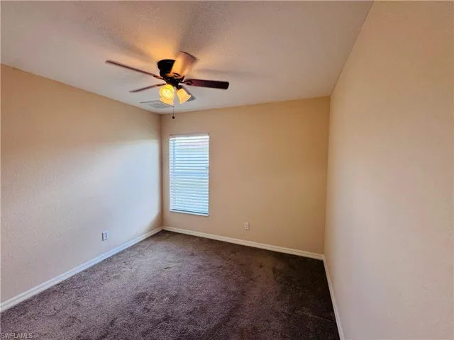 Spare room with a ceiling fan and carpet floors
