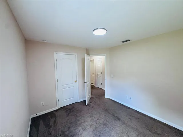 Carpeted empty room featuring baseboards