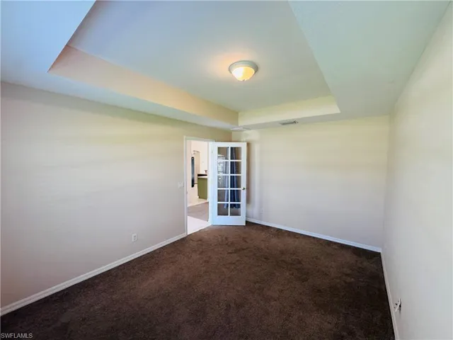 Unfurnished room with carpet and a raised ceiling