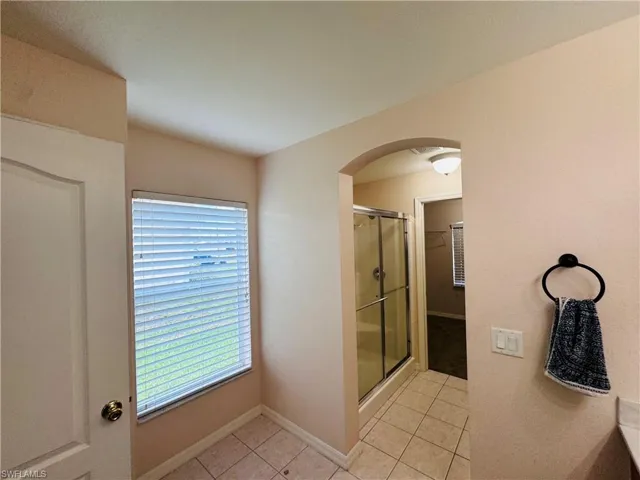 Bathroom featuring tile patterned flooring and a stall shower