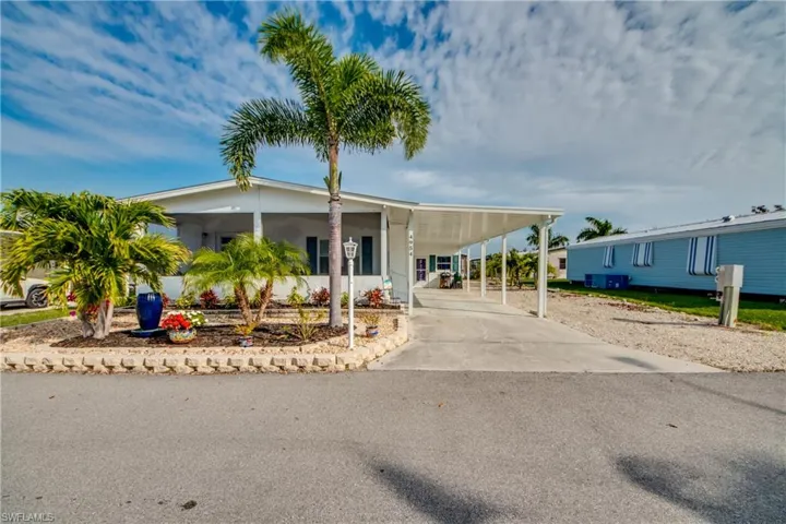 Manufactured / mobile home featuring a carport and concrete driveway