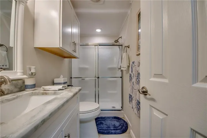 Laundry area featuring cabinet space, washer and clothes dryer, crown molding, and light wood-type flooring