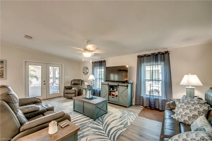 Kitchen featuring open floor plan, plenty of natural light, white cabinetry, and a breakfast bar area