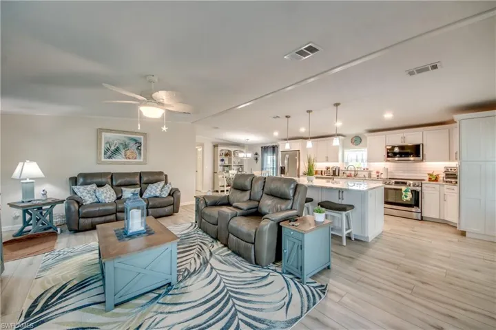 Living area with crown molding, light wood finished floors, and ceiling fan