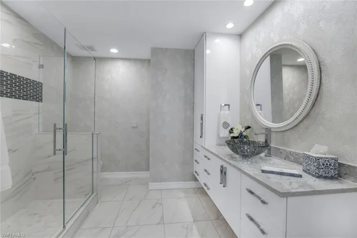 Bathroom featuring vanity and a shower with door