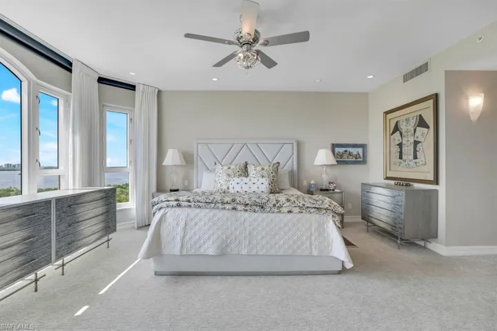 Bedroom featuring multiple windows, light carpet, and ceiling fan