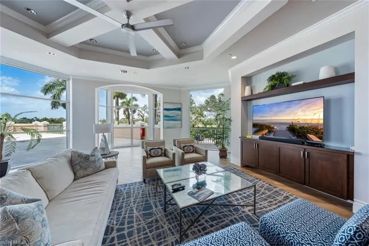 Living room with ceiling fan, beam ceiling, ornamental molding, light hardwood / wood-style flooring, and coffered ceiling