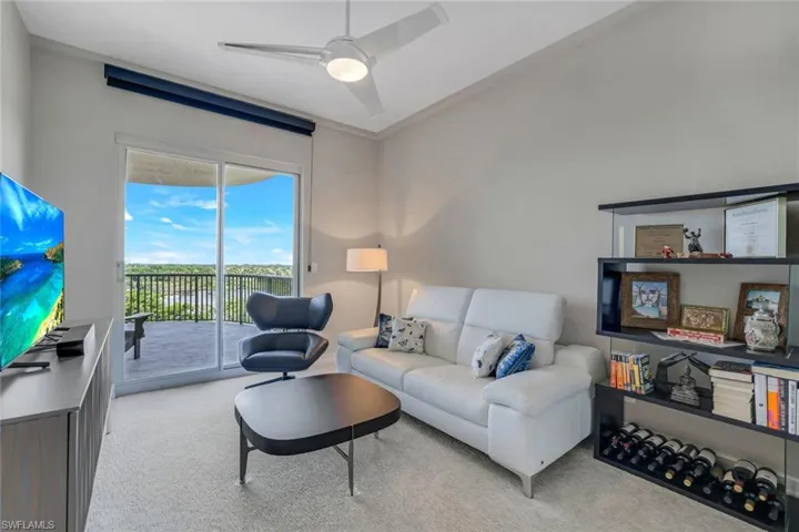 Living room with ceiling fan and light colored carpet