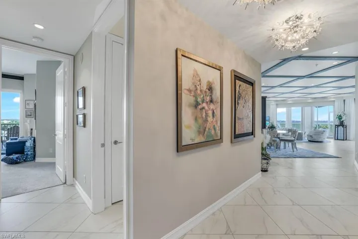 Corridor with a notable chandelier and plenty of natural light