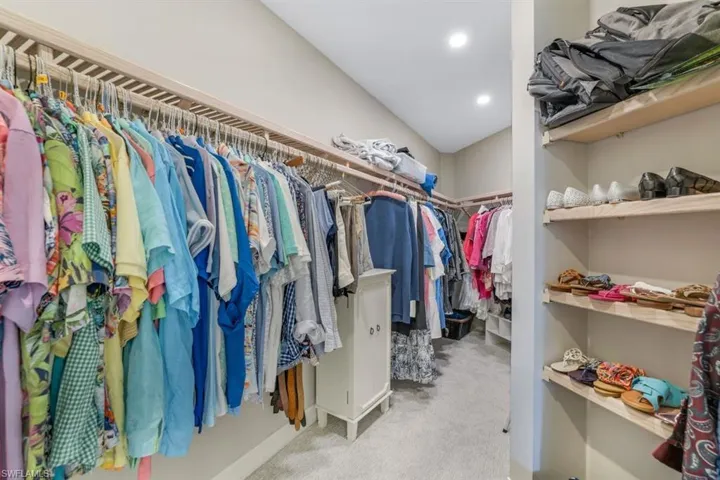 Spacious closet with light carpet