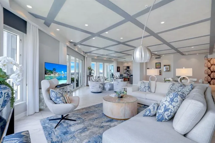 Living room featuring coffered ceiling and a healthy amount of sunlight