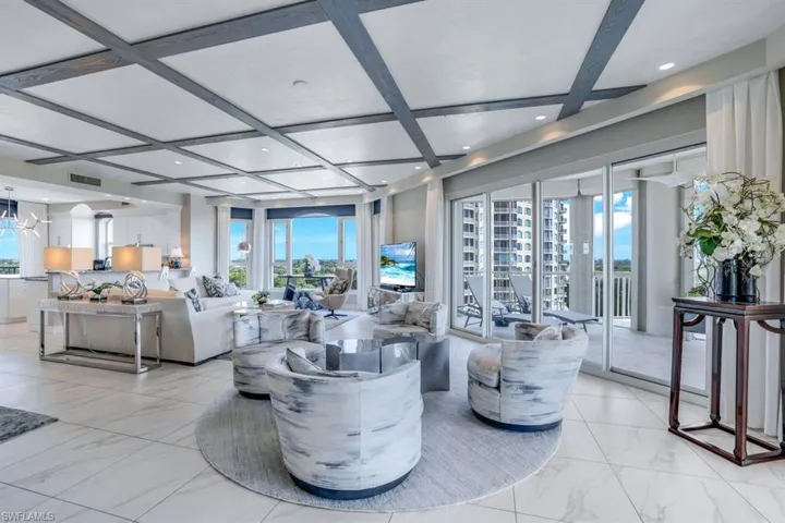 Living room with coffered ceiling, an inviting chandelier, and beam ceiling