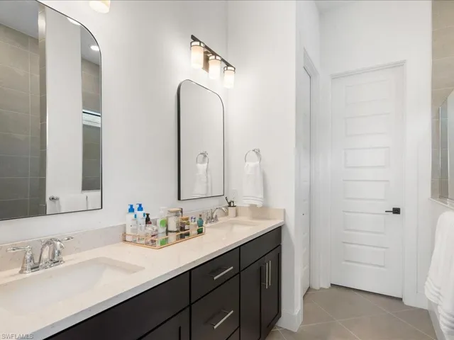 Bathroom with tile patterned flooring, a sink, and double vanity