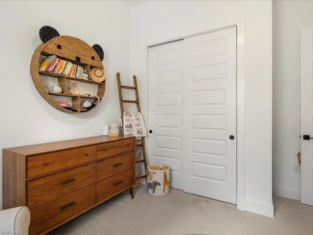 Bedroom featuring light colored carpet and a closet