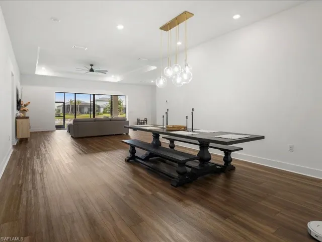 Dining room featuring dark wood finished floors, ceiling fan, baseboards, and recessed lighting